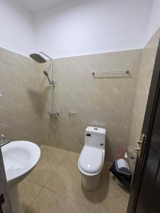 a bathroom with a white toilet and a sink at La Kribienne in Cotonou