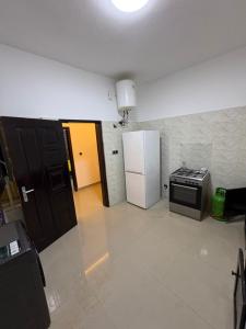a kitchen with a stove and a refrigerator at La Kribienne in Cotonou