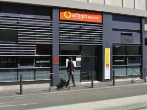 a man walking in front of aadobe access store at Aparthotel Adagio Access Toulouse St Cyprien in Toulouse