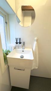 a bathroom with a white sink and a mirror at Vinkelgata 20 Guesthouse in Stavanger
