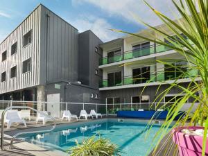 a building with a swimming pool in front of a building at ibis Styles Quiberon Centre in Quiberon