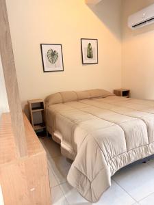 a bedroom with a bed and two pictures on the wall at Apart Zona Paula in San Juan