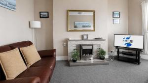 a living room with a couch and a tv at Lady Mary Sea View in Rothesay