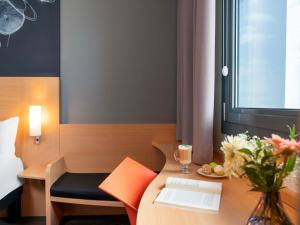 a room with a desk with a laptop and a vase of flowers at ibis Ankara Airport Hotel in Ankara +100 photos