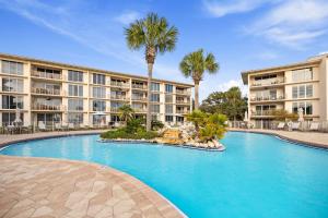a swimming pool in front of a building with palm trees at HP 124 Condo by 30A Escapes in Rosemary Beach