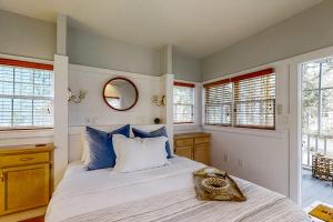 a bedroom with a bed with blue pillows and a mirror at Fish, Hike & Unwind! Quiet Haven in Steinhatchee in Steinhatchee +19 photos