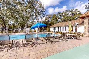 a pool with chairs and a table and a blue umbrella at Fish, Hike & Unwind! Quiet Haven in Steinhatchee in Steinhatchee