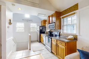 a kitchen with white walls and wooden cabinets at Fish, Hike & Unwind! Quiet Haven in Steinhatchee in Steinhatchee