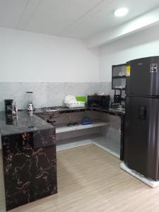 a kitchen with a black counter and a refrigerator at Nirvana Home Calima Darien in Darién +18 photos