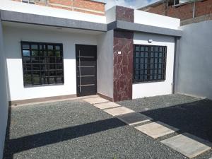 a white house with a door and two windows at Nirvana Home Calima Darien in Darién