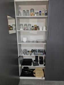 a kitchen pantry with white shelves with food items at Tarrentoela garden flatlet in Kathu