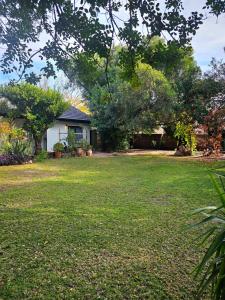 a yard with a house and a tree at Tarrentoela garden flatlet in Kathu