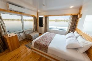 a bedroom with a large bed and large windows at Crociera sul Nilo Luxury in Luxor
