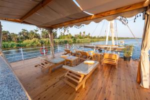 a wooden deck with tables and chairs on a boat at Crociera sul Nilo Luxury in Luxor