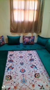 a bed with a colorful blanket on top of it at شقق دبي مفروشة in Tarfaya
