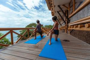 two children standing on blue mats on a deck at Pao Pao Cartagena in Isla Grande