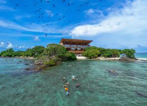 people swimming in the ocean in front of a hotel at Pao Pao Cartagena in Isla Grande +153 photos