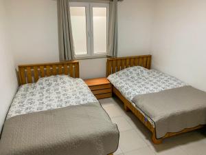 two beds sitting in a room with a window at Lake of Diber in Debar