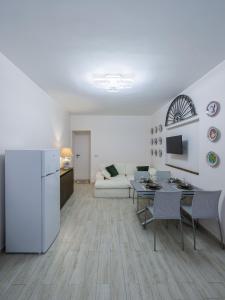 a white living room with a white couch and a table at Catherine's Home Central Apartment in Taormina