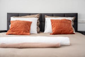 two orange pillows are sitting on a bed at Alvastay - Cozy studio in Haaltert