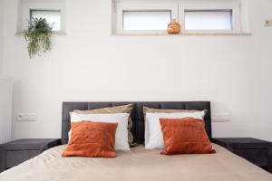 a bedroom with a bed with orange pillows at Alvastay - Cozy studio in Haaltert