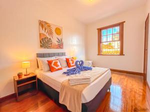a bedroom with a bed with a blue ribbon on it at Wafeh Guest House - Fleming - Bar & Jardim in Belo Horizonte +7 photos