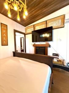 a bedroom with a bed and a flat screen tv at Secret Hideaway in Guápiles