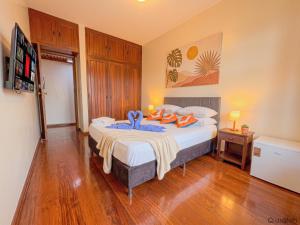 a bedroom with a bed with a blue towel on it at Wafeh Guest House - Fleming - Bar & Jardim in Belo Horizonte