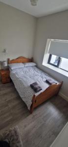 a bedroom with a wooden bed and a window at Bridie's Cottage in Mullagh +2 photos