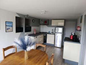 a kitchen with a table and a kitchen with a refrigerator at "La maison fleurie" Sud Vendée 85 in Avrillé