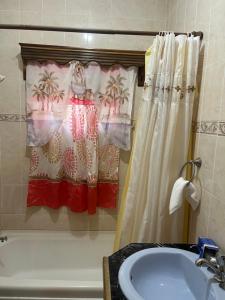 a bathroom with a shower curtain and a tub and a sink at Driftwood Suite in Runaway Bay