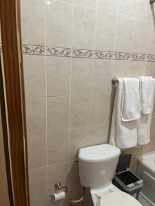 a bathroom with a toilet and towels on the wall at Driftwood Suite in Runaway Bay