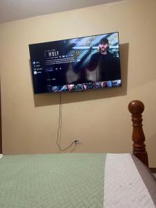 a flat screen tv hanging on a wall next to a bed at Driftwood Suite in Runaway Bay
