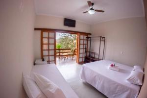 a bedroom with two beds and a living room at Pousada Vale Verde com café da manhã in Lindóia