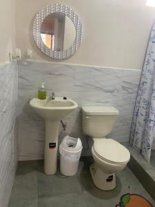 a bathroom with a toilet and a sink and a mirror at El refugio de Lolita in Loja