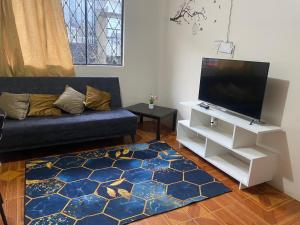 a living room with a couch and a flat screen tv at El refugio de Lolita in Loja