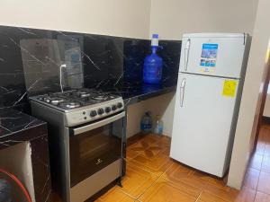 a kitchen with a stove and a refrigerator at El refugio de Lolita in Loja +6 photos