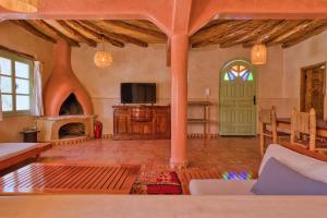 a large living room with a fireplace and a tv at Villa Nouran Beldi in Essaouira