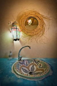 a bathroom sink with a mirror and a sink at Villa Nouran Beldi in Essaouira
