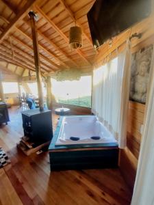 a jacuzzi tub in a room with wooden floors at De oio no arroio in Cambará