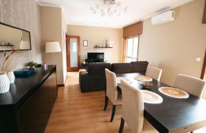 a dining room and living room with a table and chairs at S. Mamede House - Penafiel in Recezinhos