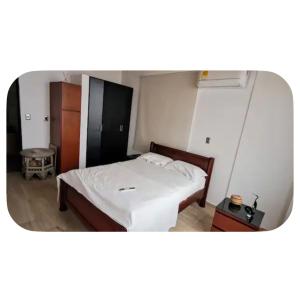 a small bedroom with a bed with white sheets at Casa totalmente amoblada in Yopal