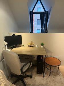 a desk with a computer and a chair in a room at Business Executive Studio in Geel +5 photos
