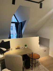 an attic office with a desk and a window at Business Executive Studio in Geel