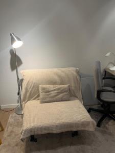 a bed with a pillow and a lamp and a chair at Business Executive Studio in Geel