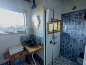 a blue tiled bathroom with a sink and a shower at De oio no arroio in Cambará +43 photos