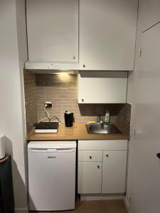 a small kitchen with white cabinets and a sink at Business Executive Studio in Geel