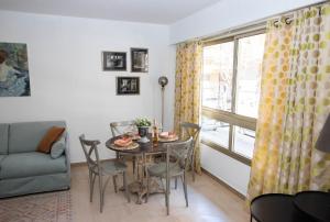 a living room with a table and chairs and a window at Cap SOLEIL in Antibes