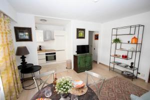 a living room with a table and chairs and a kitchen at Cap SOLEIL in Antibes