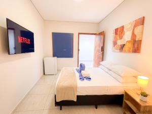 a small bedroom with a bed and a television at Wafeh Guest House - Fleming - Bar & Jardim in Belo Horizonte